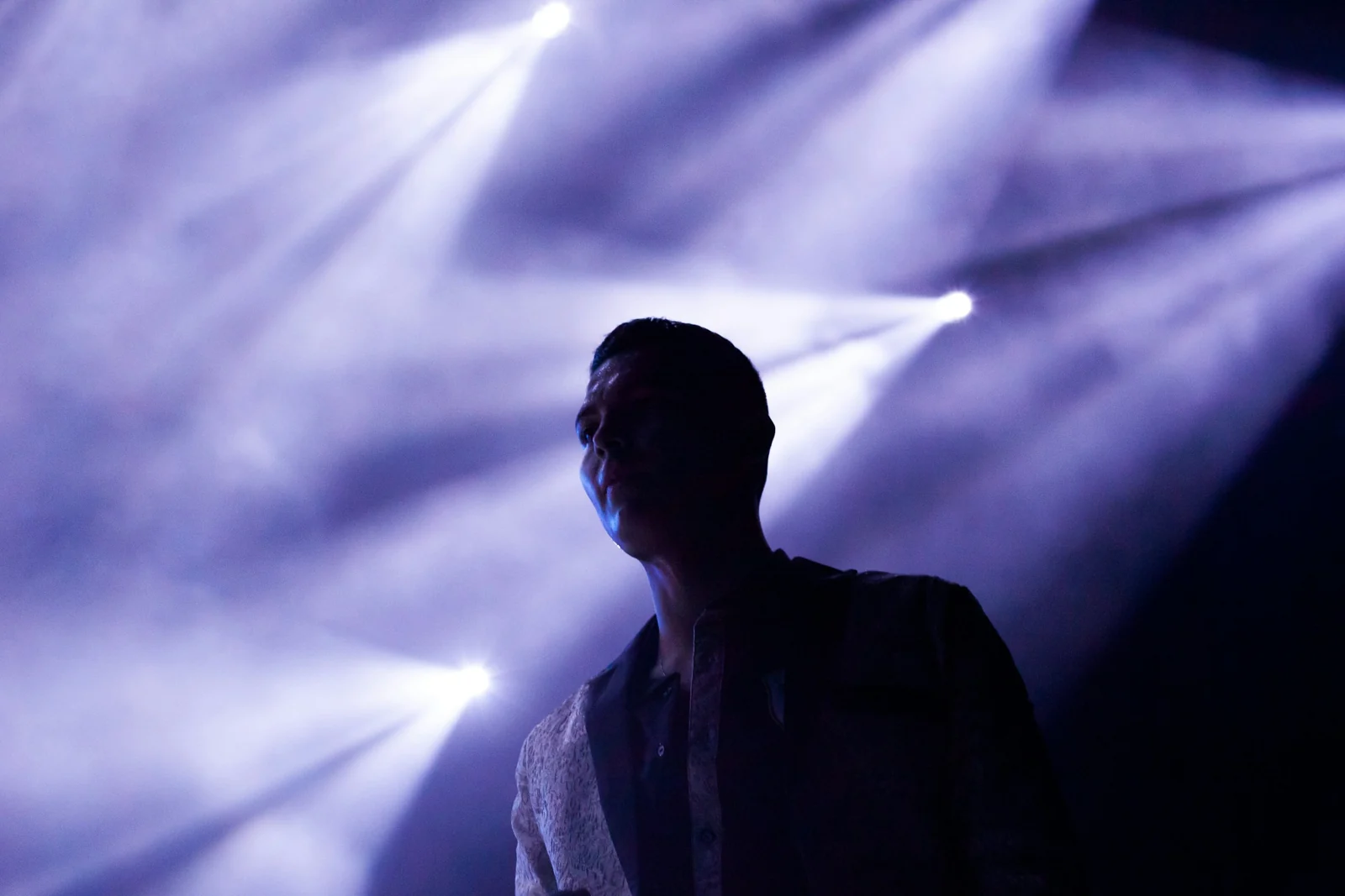 Silueta unui artist pe scenă, în lumina reflectoarelor
